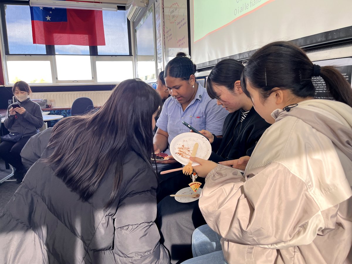 A group of diverse female international students gathered together in a classroom during a social or...
