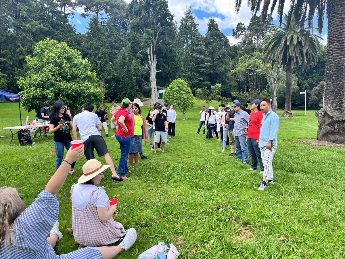 A diverse group of international students and staff enjoying an outdoor social activity and picnic in a...