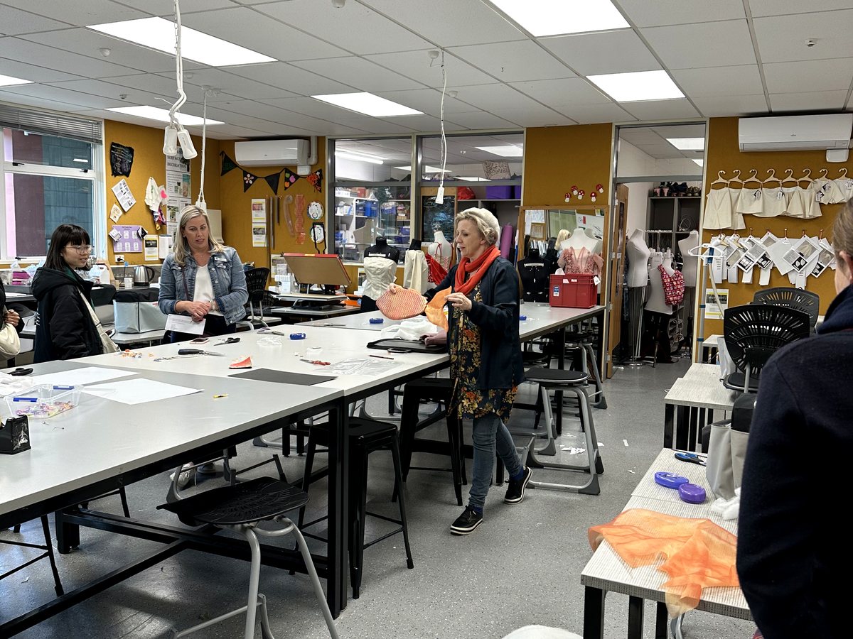 An interactive workshop or classroom session at WIE, featuring a teacher demonstrating materials in a...