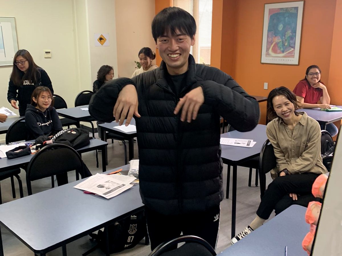 A group of diverse international students participating in a lively, interactive classroom activity at...
