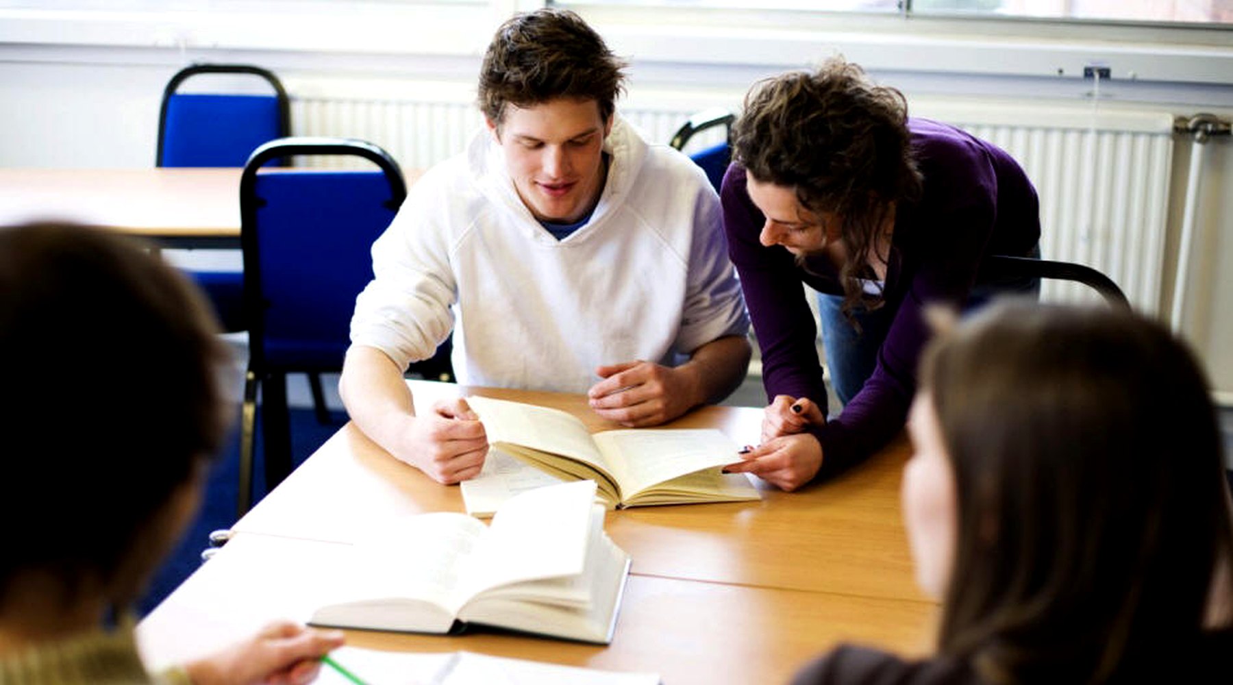 WIE teacher supporting a student during classroom study